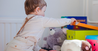 criança a abrir e explorar os seus brinquedos